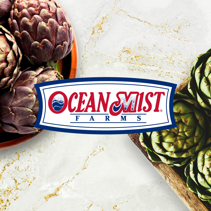 Ocean Mist Farms logo on background image of marble countertop with a box of green artichokes and a bowl of purple artichokes